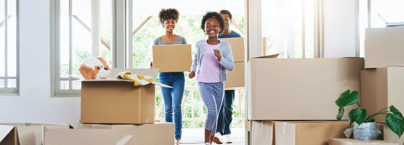 Small family surrounded by boxes as they move into their new home with a home warranty plan